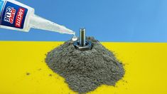 a pile of dirt next to a bottle of water on top of a yellow and blue table