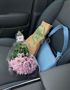 flowers in the back seat of a car, with a bag on the floor next to it