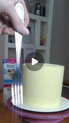 a person holding a knife and fork over a cake