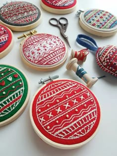 several different types of embroidered ornaments on a table with scissors and thread spools