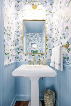 a white sink sitting under a mirror in a bathroom next to a wall mounted light