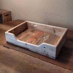 a wooden tray sitting on top of a wooden table next to two boxes with drawers