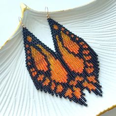 These long beaded earrings are inspired by the beauty of the butterfly with orange tones. Handcrafted with meticulous attention to detail, they exude timeless sophistication. Perfect for adding a touch of celestial charm to any ensemble, these earrings are sure to become a cherished addition to your jewelry collection. Dimensions: - Length: 10 cm (3.9 inches) - Width: 3 cm (1.2 inches) Butterfly Beaded Earrings, Long Beaded Earrings, Long Chandelier, Bead Fringe, Butterfly Wing Earrings, Beaded Fringe Earrings, Orange Butterfly, Orange Tones, Handmade Earrings Beaded