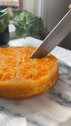 a person is cutting into a cake with a large knife on top of the cake