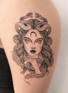 a woman's thigh with a snake tattoo on her leg and the head of a demon