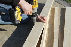 a man is using a drill to cut plywood planks with a power tool