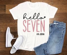 a t - shirt with the words hello seven on it next to jeans and sneakers