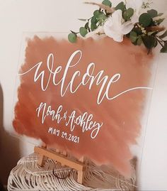 a welcome sign on top of a wooden easel