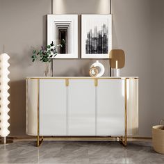 a white and gold sideboard with two pictures on the wall