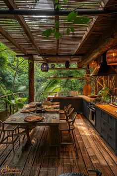 an outdoor kitchen and dining area with wood flooring in the middle, surrounded by greenery