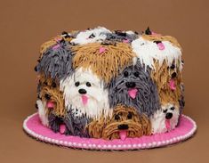 there is a cake decorated with many dogs on it's sides and pink trim