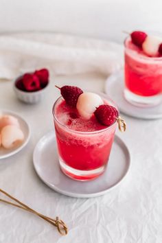 two glasses filled with raspberry mousse on top of a white table