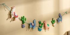 several stuffed animals are hanging on a clothesline with cactuses and cacti