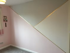 the corner of a room with pink walls and gold trimmings on the wall