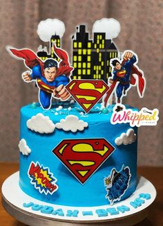 a superman cake with blue frosting and decorations