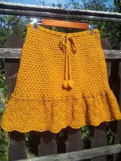 a yellow crocheted skirt hanging on a clothes line