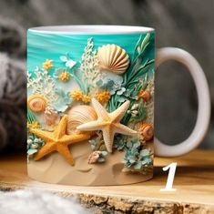 a coffee mug with seashells and starfish painted on it sitting on a table