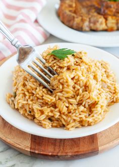 a fork is stuck into some rice on a plate