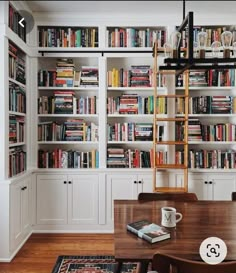 a dining room table in front of a bookcase filled with books