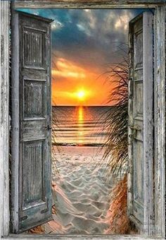 an open door leading to the beach at sunset