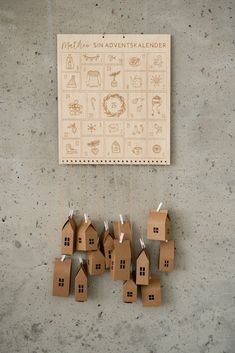 cardboard houses are hanging from strings on the wall