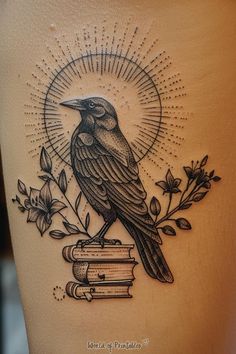 a black bird sitting on top of a stack of books