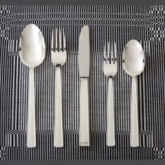 four forks, two spoons and one knife on a place mat