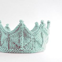 a knitted green crown sitting on top of a table