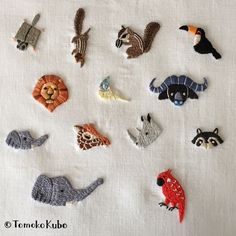 there are many different animal pins on the white table cloth, including zebras, giraffes, and other animals