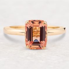 an orange and brown diamond ring on a white surface