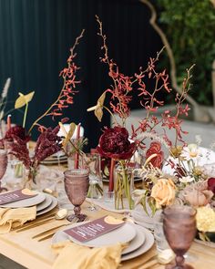 the table is set with flowers and place settings