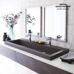 a bathroom sink with two mirrors above it and candles on the counter in front of it