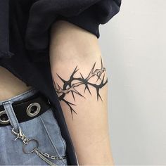 a black and white photo of a tattoo on the left arm with barbed wire around it