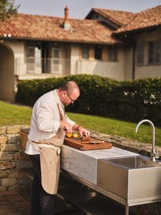 a man in an apron preparing food on a grill