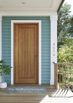 a wooden door on the side of a blue house next to a porch with potted plants