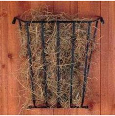 a basket filled with hay sitting on top of a wooden floor next to a wall