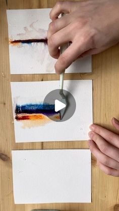 someone is painting on paper with a paintbrush