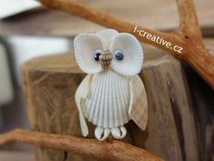 an owl figurine sitting on top of a tree branch next to a piece of wood