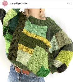 a doll is wearing a green sweater with multicolored squares on it's sleeves