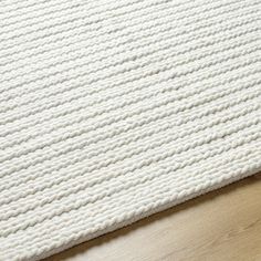 a white rug on top of a wooden floor