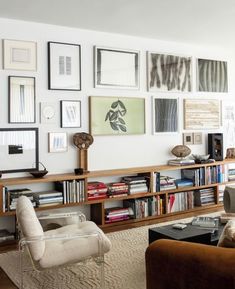 a living room filled with lots of furniture and pictures on the wall above it's bookshelf