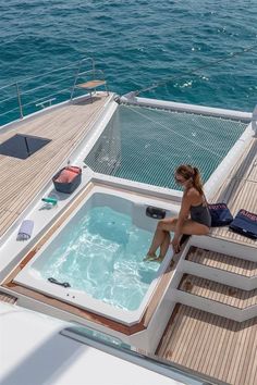 a woman sitting in an outdoor jacuzzi on the deck of a sailboat