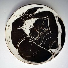 a black and white plate with a drawing of a woman holding a cat on it