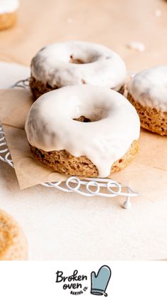 two glazed donuts sitting on top of a piece of paper next to each other