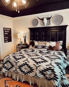 a bed with black and white bedspread sitting in a bedroom next to two lamps