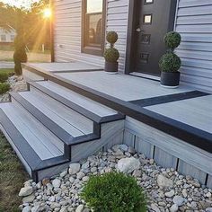 a house with stone steps leading up to the front door and landscaping area next to it