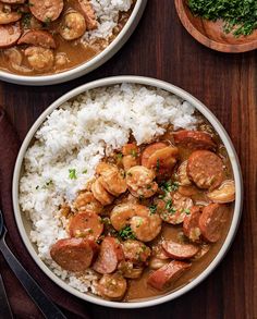 two bowls filled with shrimp and rice on top of a wooden table