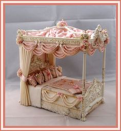 a dollhouse bed with pink and white curtains on it's headboard, made to look like a canopy bed