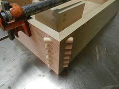 a wooden box with a large metal tool sticking out of it's top and inside