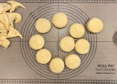 doughnuts are arranged in a circle on a wire rack with a cloth next to it